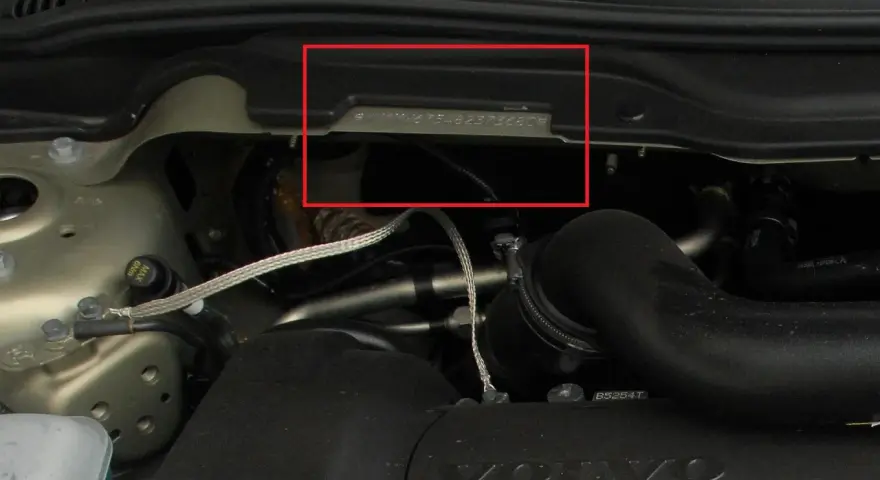 Widoczny numer nadwozia wybity na metalowej płytce w komorze silnika Volvo.