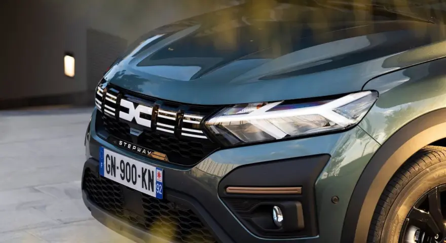 Nowy Dacia Sandero Stepway w zielonym kolorze, z charakterystycznym logo i nowoczesnymi światłami LED.