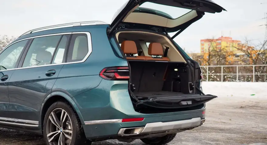Zielony BMW X7 z otwartym bagażnikiem, idealny na rodzinne wyjazdy. Sprawdź aktualną bmw x7 cena.