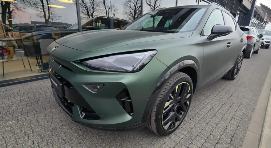 Nowa Cupra w matowym, zielonym kolorze prezentuje się imponująco na tle salonu.