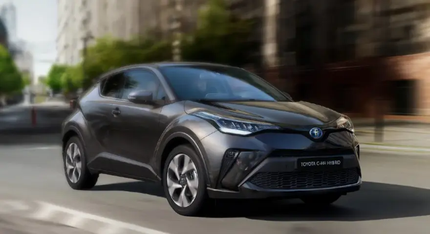 Ciemnoszara Toyota C-HR Hybrid w ruchu miejskim. Zastanawiasz się, ile pali Toyota C-HR Hybrid? Ten stylowy crossover zachwyca niskim spalaniem.
