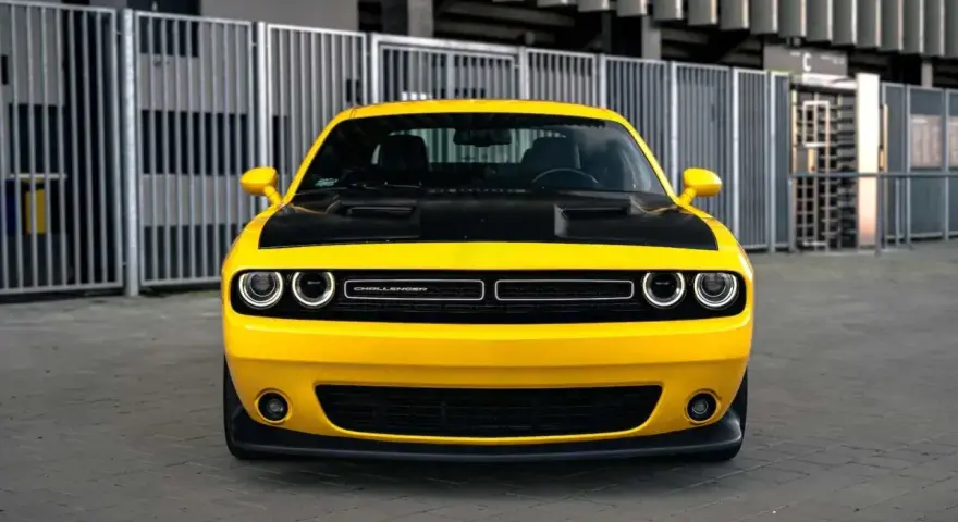 Żółty Dodge Challenger z czarną maską, gotowy do jazdy. Sprawdź jego atrakcyjną dodge challenger cena!