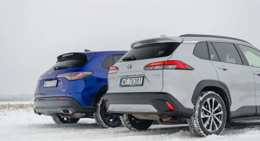 Porównanie hybryd: niebieska Honda CR-V e:HEV i srebrna Toyota Corolla Cross Hybrid AWD na śniegu. Którą wybrać?