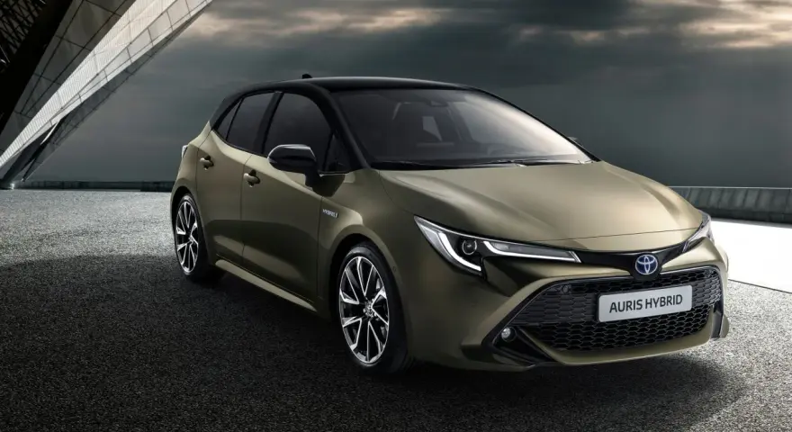Nowy Toyota Auris Hybrid, stylowy następca Priusa, prezentuje się dynamicznie na tle nowoczesnej architektury.