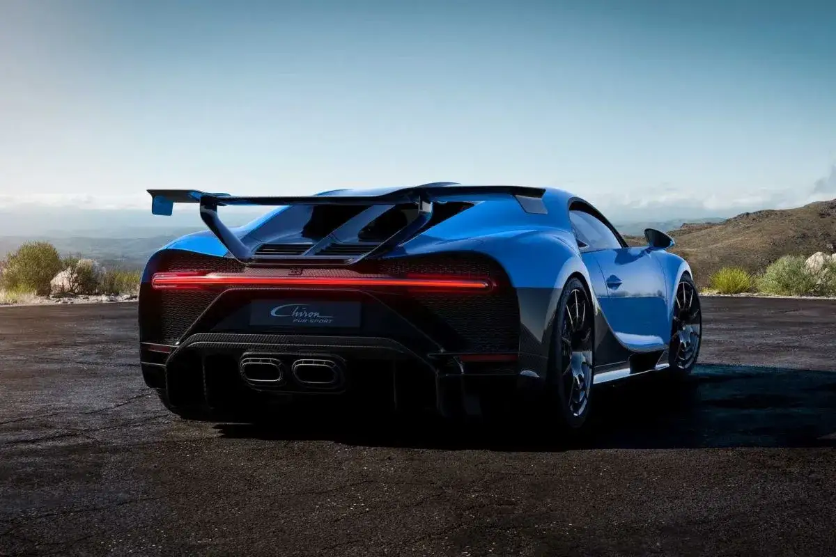 Niebieski Bugatti Chiron Pur Sport z masywnym skrzydłem i czterema końc&oacute;wkami wydechu. Zastanawiasz się, ile kosztuje Bugatti Chiron?