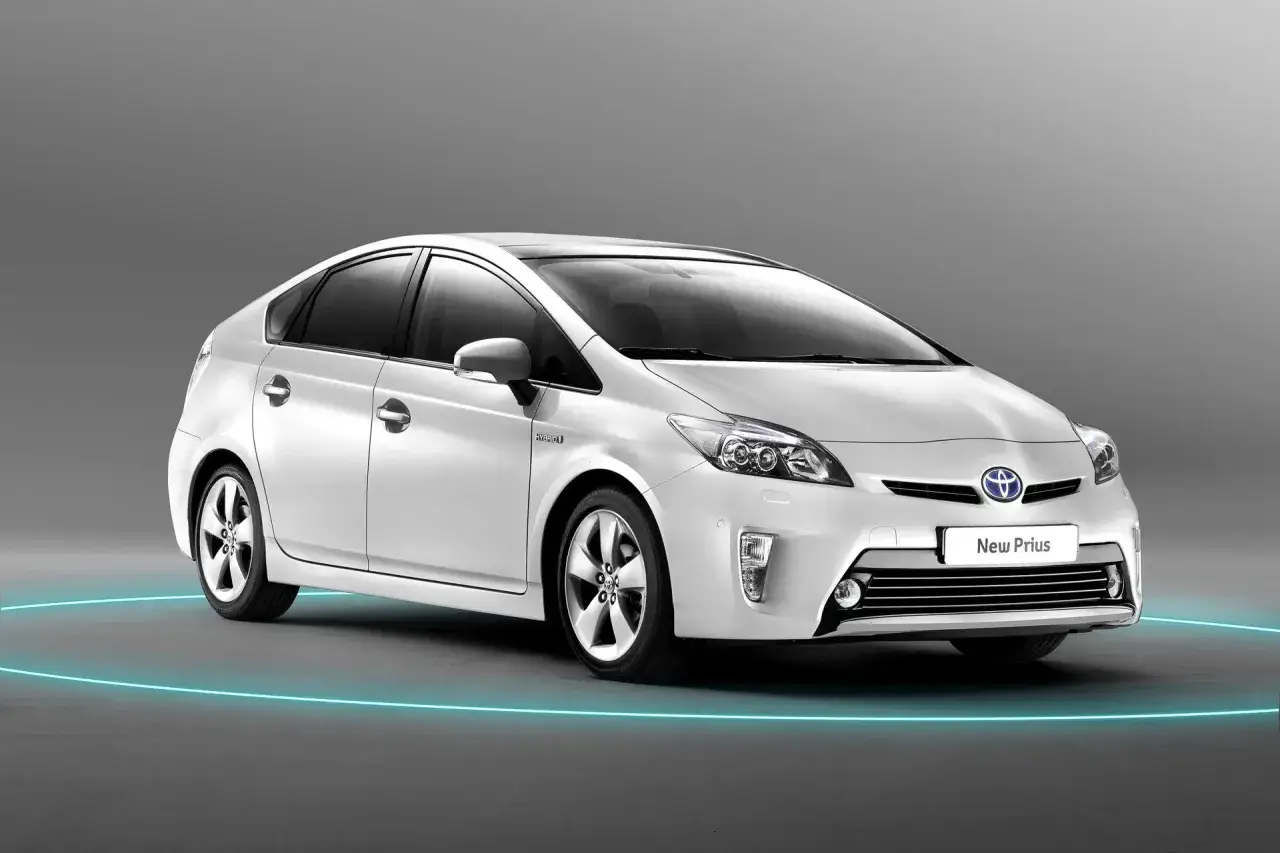 Biały Toyota Prius, hybrydowy samoch&oacute;d, prezentowany na tle, z niebieską obw&oacute;dką. Czy to Prius czy Auris?
