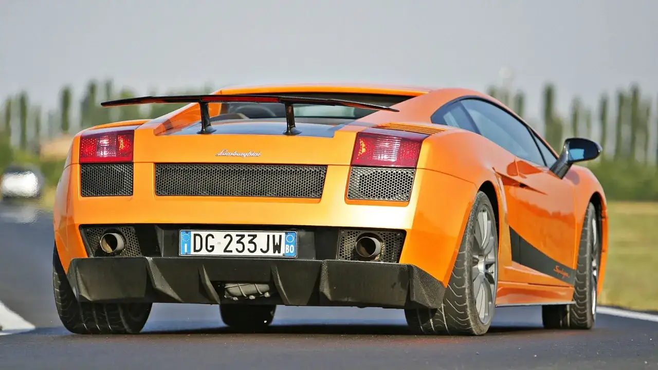 Pomarańczowe Lamborghini Gallardo na torze. Zastanawiasz się, ile kosztuje najtańsze Lamborghini? Ten model to marzenie wielu.