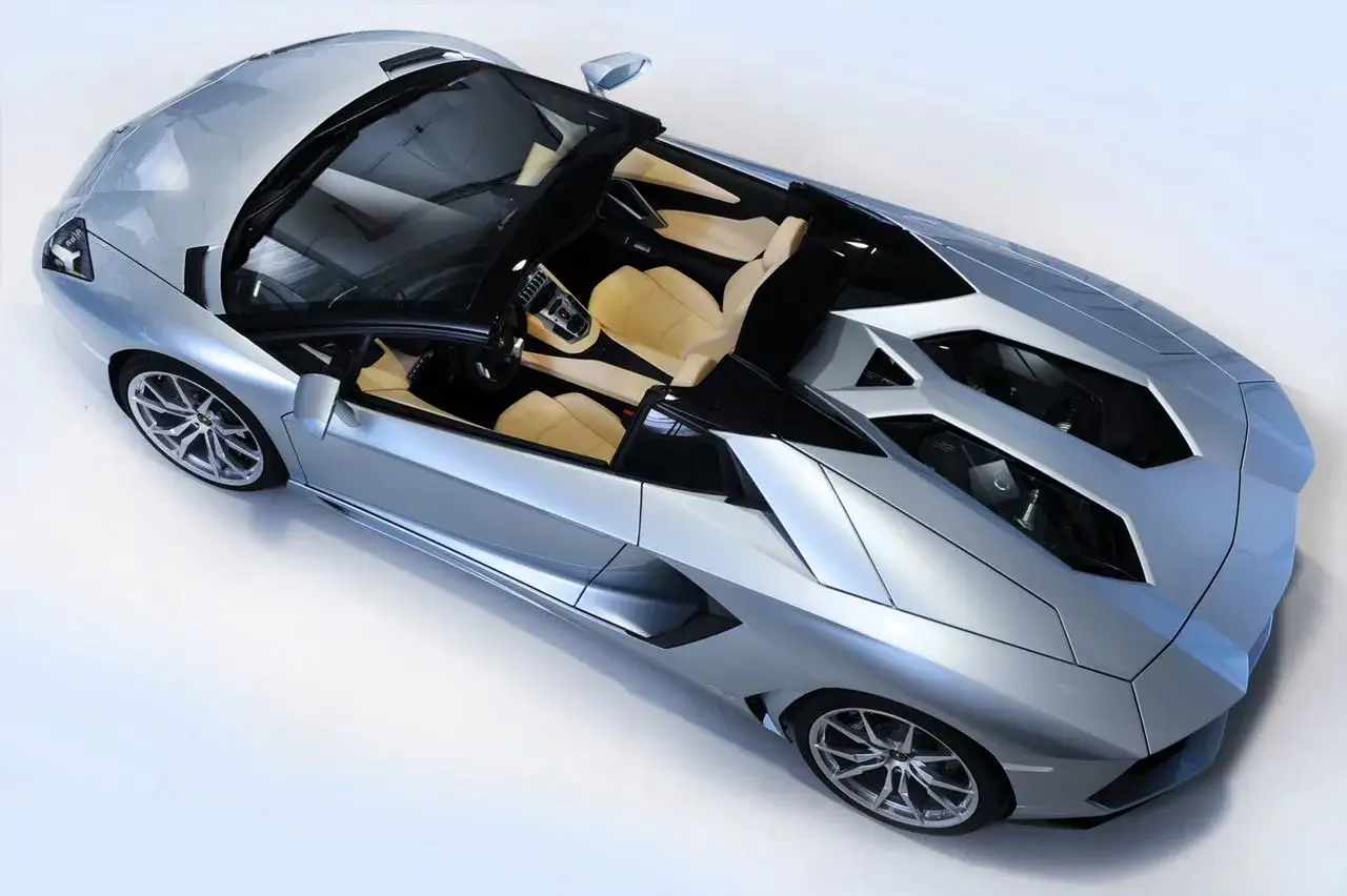 Srebrny Lamborghini Aventador Roadster z beżowym wnętrzem. Zastanawiasz się, ile kosztuje Lamborghini Aventador?