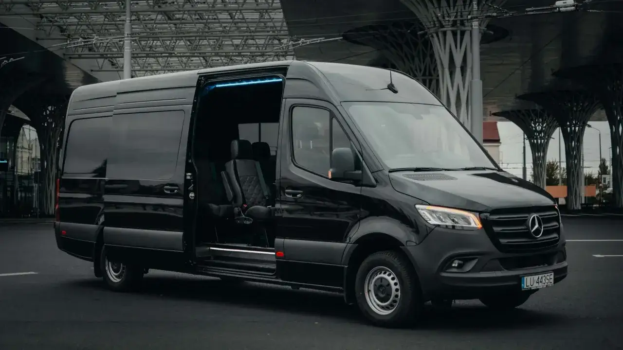 Czarny Mercedes Sprinter z otwartymi drzwiami, wygodne fotele w środku. Zastanawiasz się, ile kosztuje bus do Niemiec?