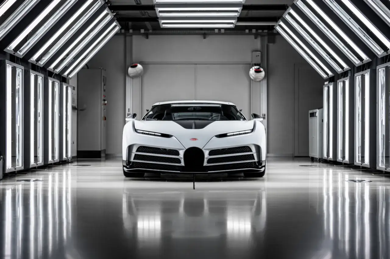 Białe Bugatti Centodieci, symbol luksusu i mocy, w nowoczesnym wnętrzu. Zastanawiasz się, ile kosztuje Bugatti Centodieci?