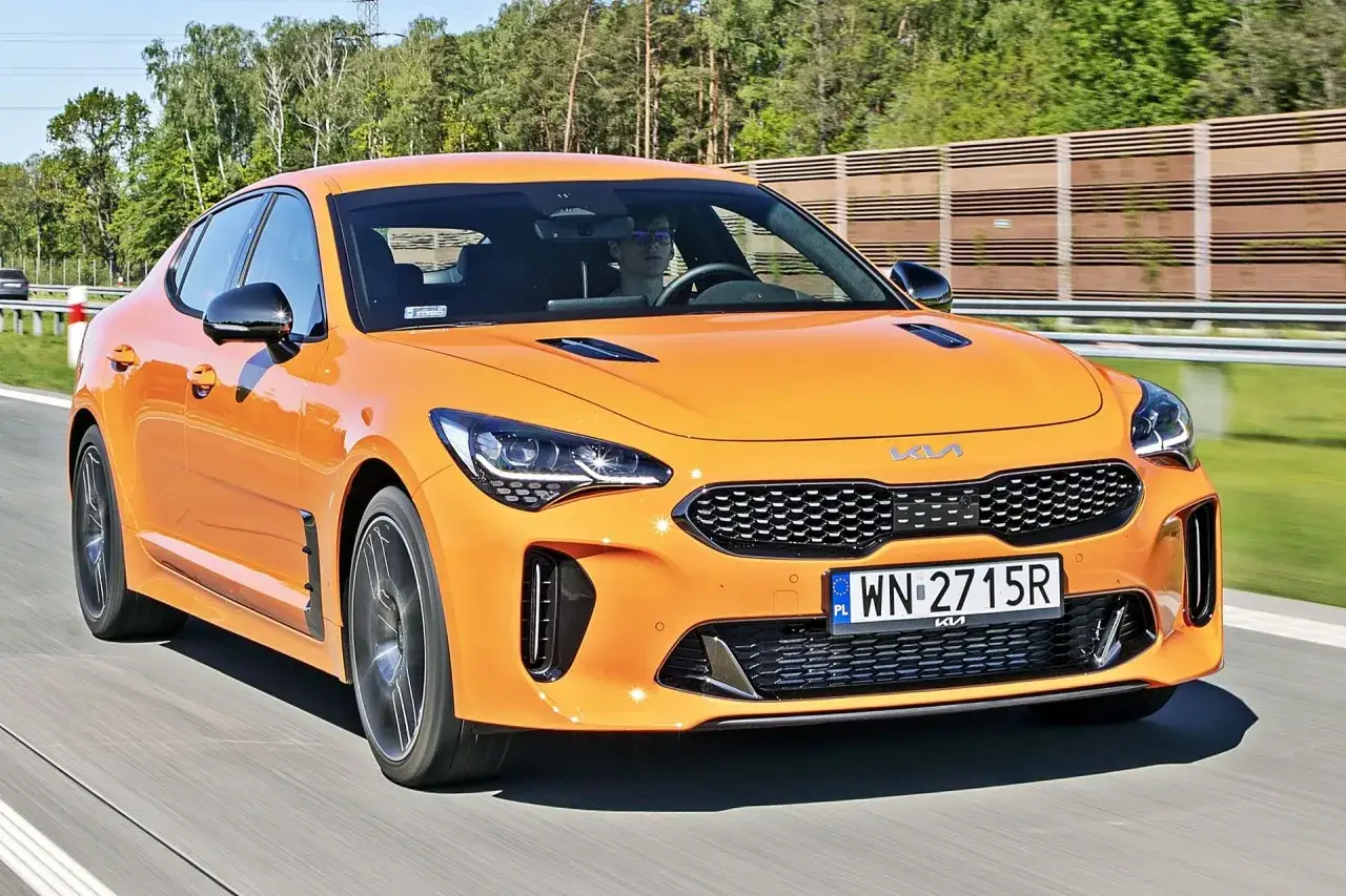 Pomarańczowy Kia Stinger na drodze. Sprawdź atrakcyjną kia stinger cena i poczuj moc!