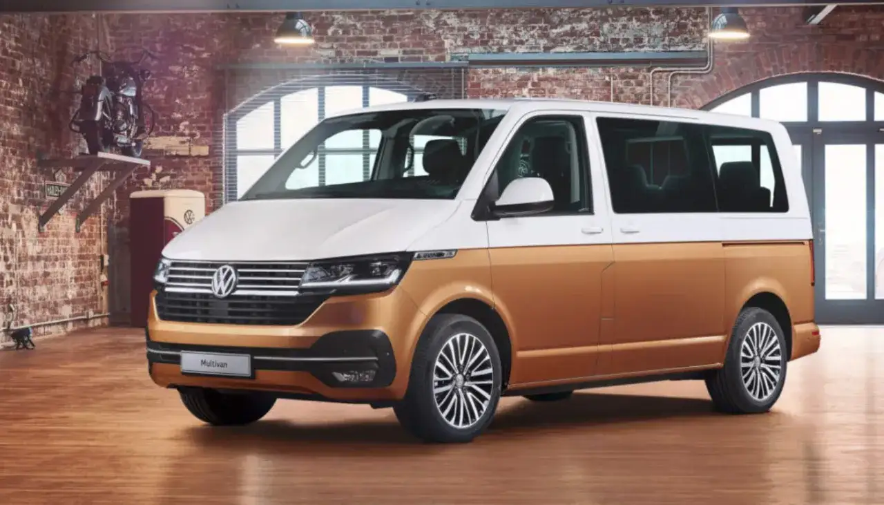 Złoty i biały bus 9 osobowy, Volkswagen Multivan, stoi w garażu. Zastanawiasz się, ile pali bus 9 osobowy?