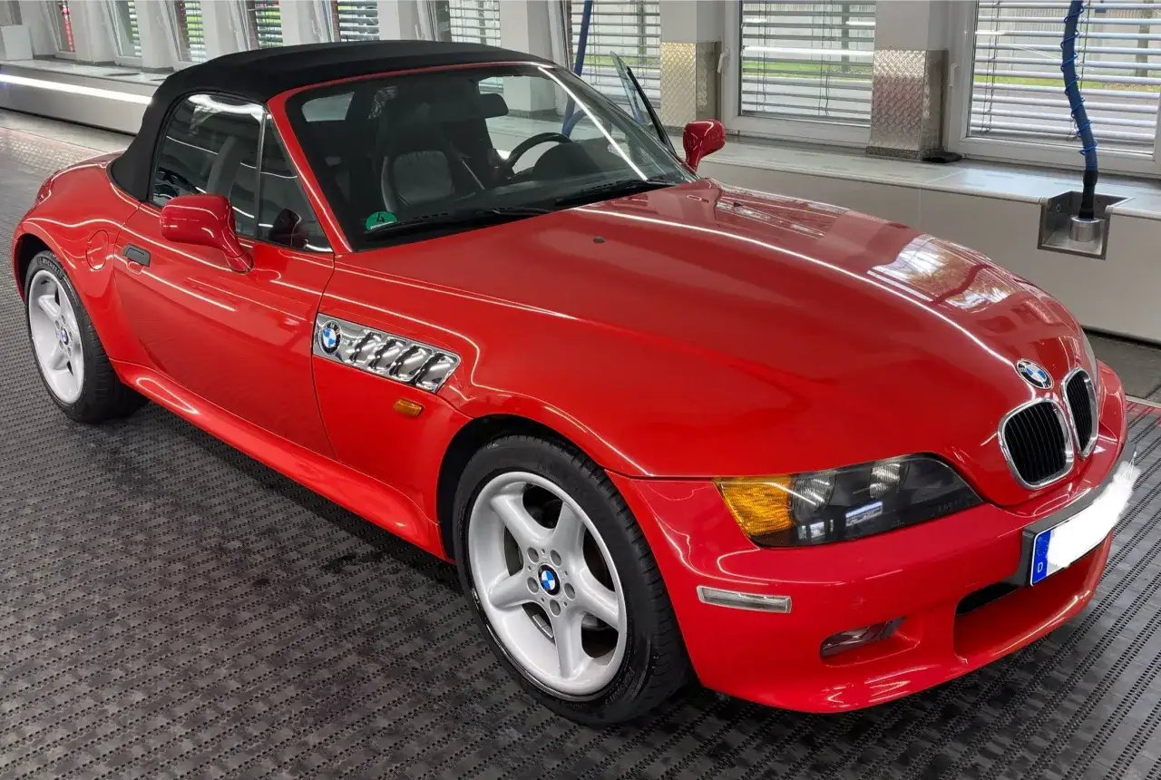 Czerwony kabriolet BMW E37 z czarnym dachem, gotowy do jazdy.