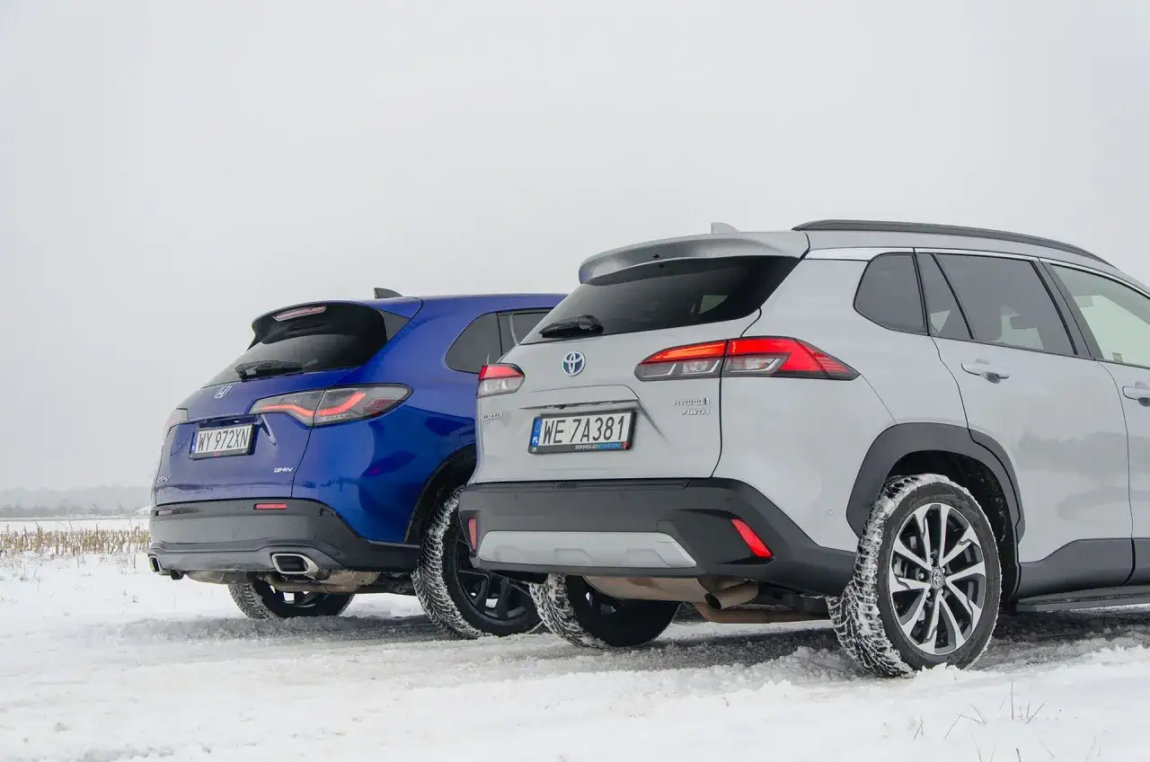 Porównanie hybryd: niebieska Honda CR-V e:HEV i srebrna Toyota Corolla Cross Hybrid na śniegu. Którą wybrać?