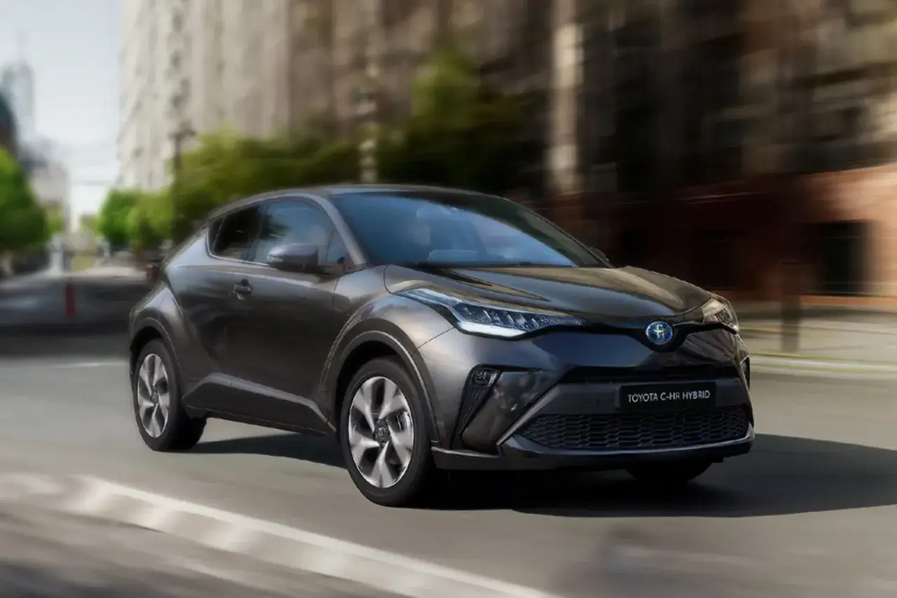 Ciemnoszary Toyota C-HR Hybrid w ruchu miejskim. Zastanawiasz się, ile pali Toyota C-HR Hybrid? Ten stylowy crossover zachwyca niskim spalaniem.