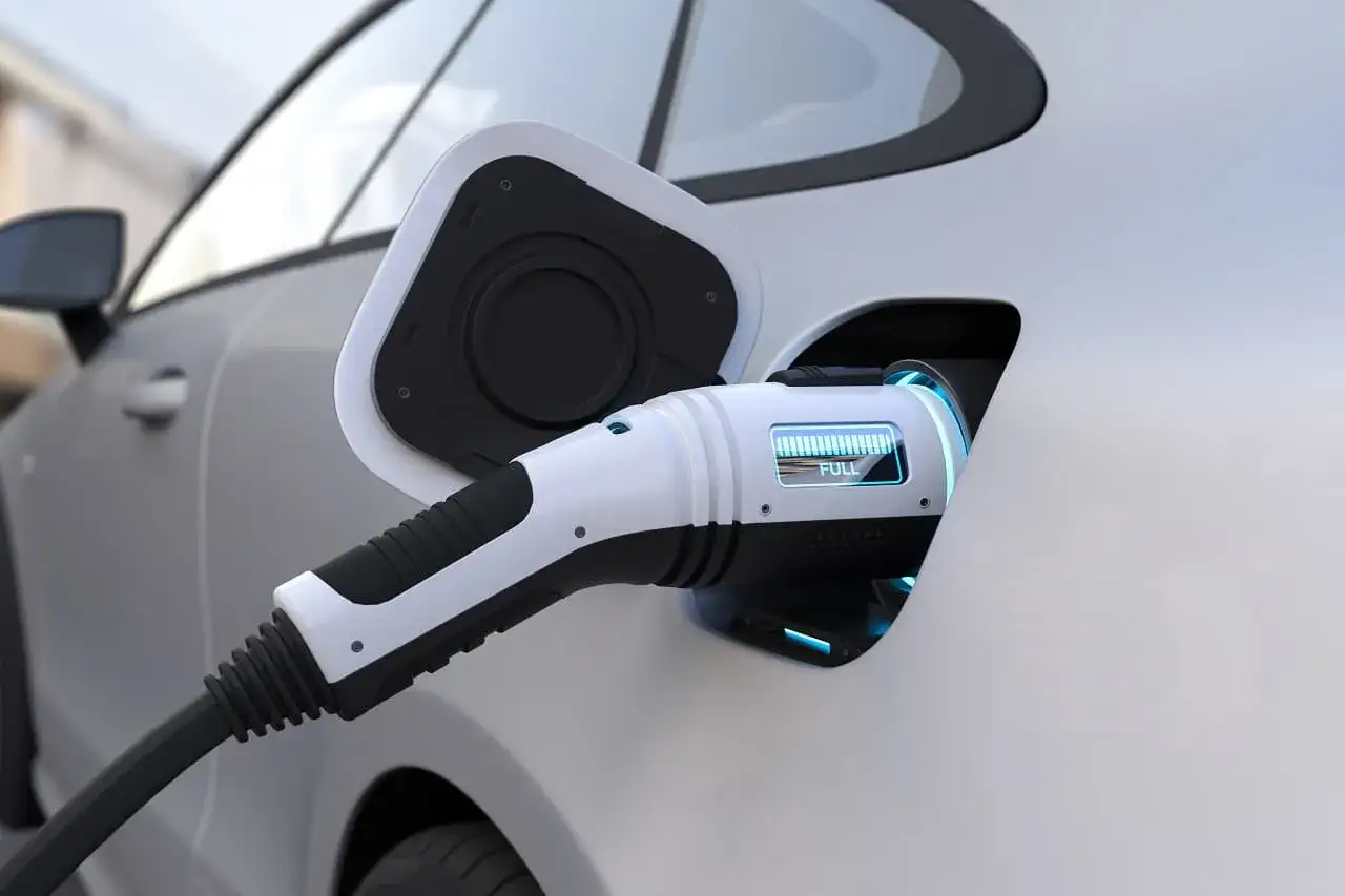 Ładowanie samochodu elektrycznego. Wskaźnik pokazuje pełne naładowanie, co pozwala ocenić, ile prądu pobiera ładowanie.