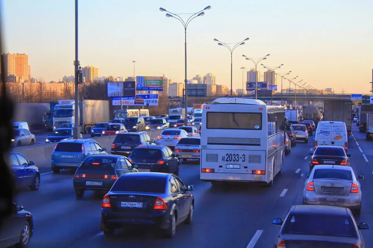 Autobus miejski w korku, obok wiele samochodów osobowych. Ile miejsc ma ten bus?