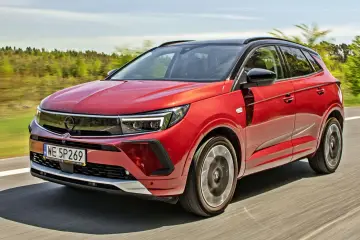 Czerwony Opel Grandland na drodze, idealny do sprawdzenia jego opel grandland cena.