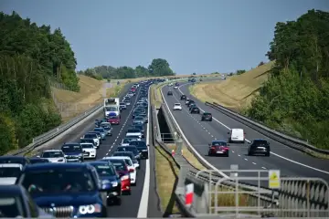Korek na autostradzie bursztynowej. Długi sznur samochodów i ciężarówek sunie powoli w upalny dzień.