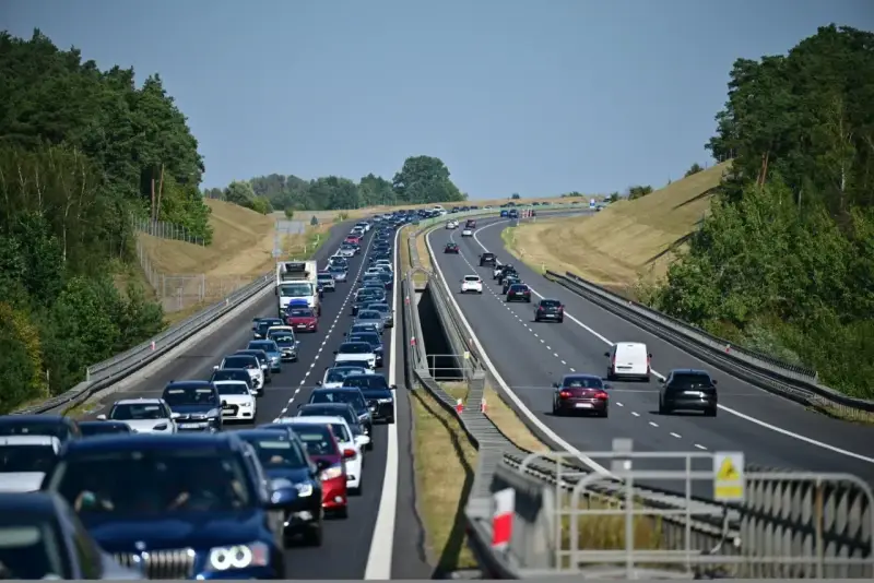 Korek na autostradzie bursztynowej. Długi sznur samochodów i ciężarówek sunie powoli w upalny dzień.