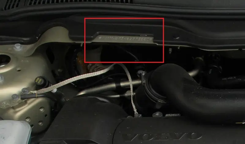 Widoczny numer nadwozia wybity na metalowej płytce w komorze silnika Volvo.